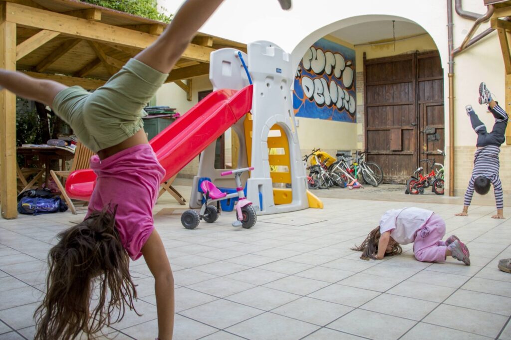 Bambine che fanno la ruota nel cortile