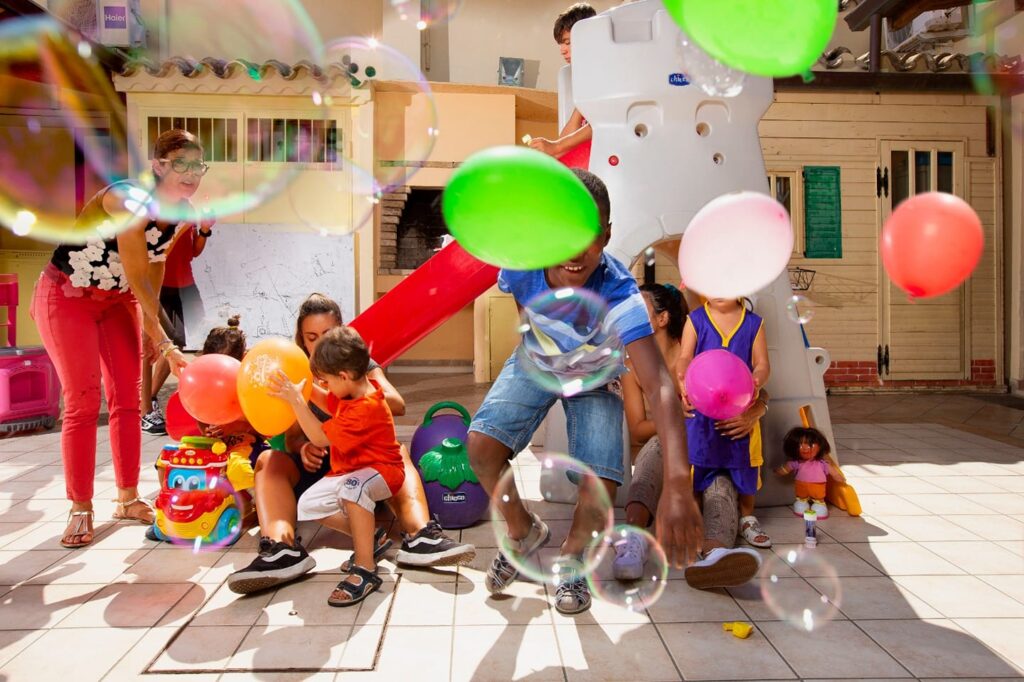 Bambini che giocano con palloncini e bolle di sapone a Domus de Luna